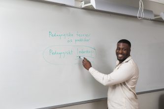 Vuxenutbildning med lärare vid whiteboard.